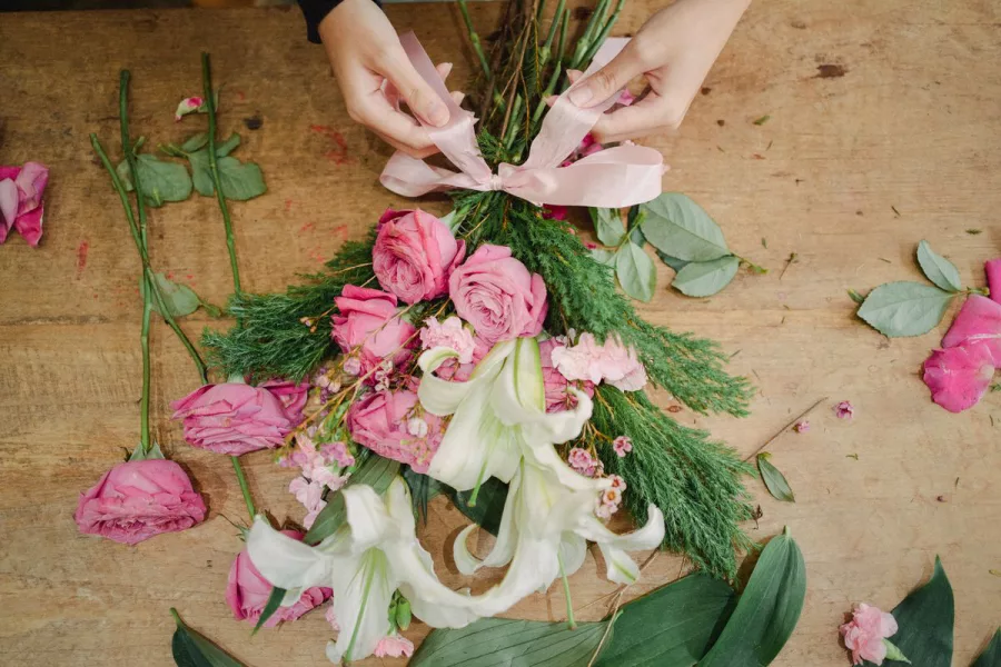 Tangan florist mengikat pita sebagai sentuhan akhir bouquet